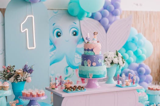 Vibrant mermaid-themed first birthday party decoration with cake, balloons, and sweets.