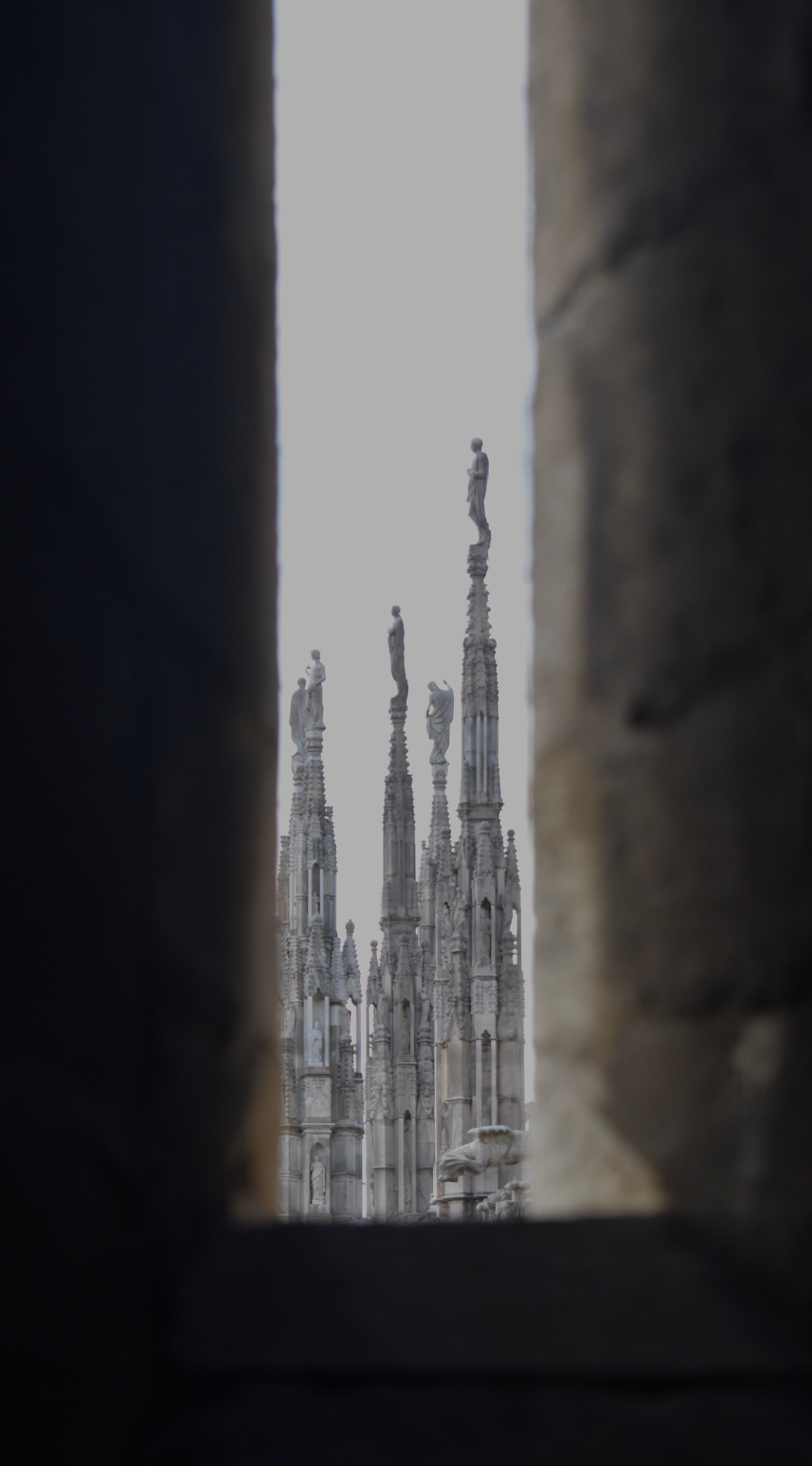 View of cathedral spires framed by a stone archway, highlighting Gothic architecture.