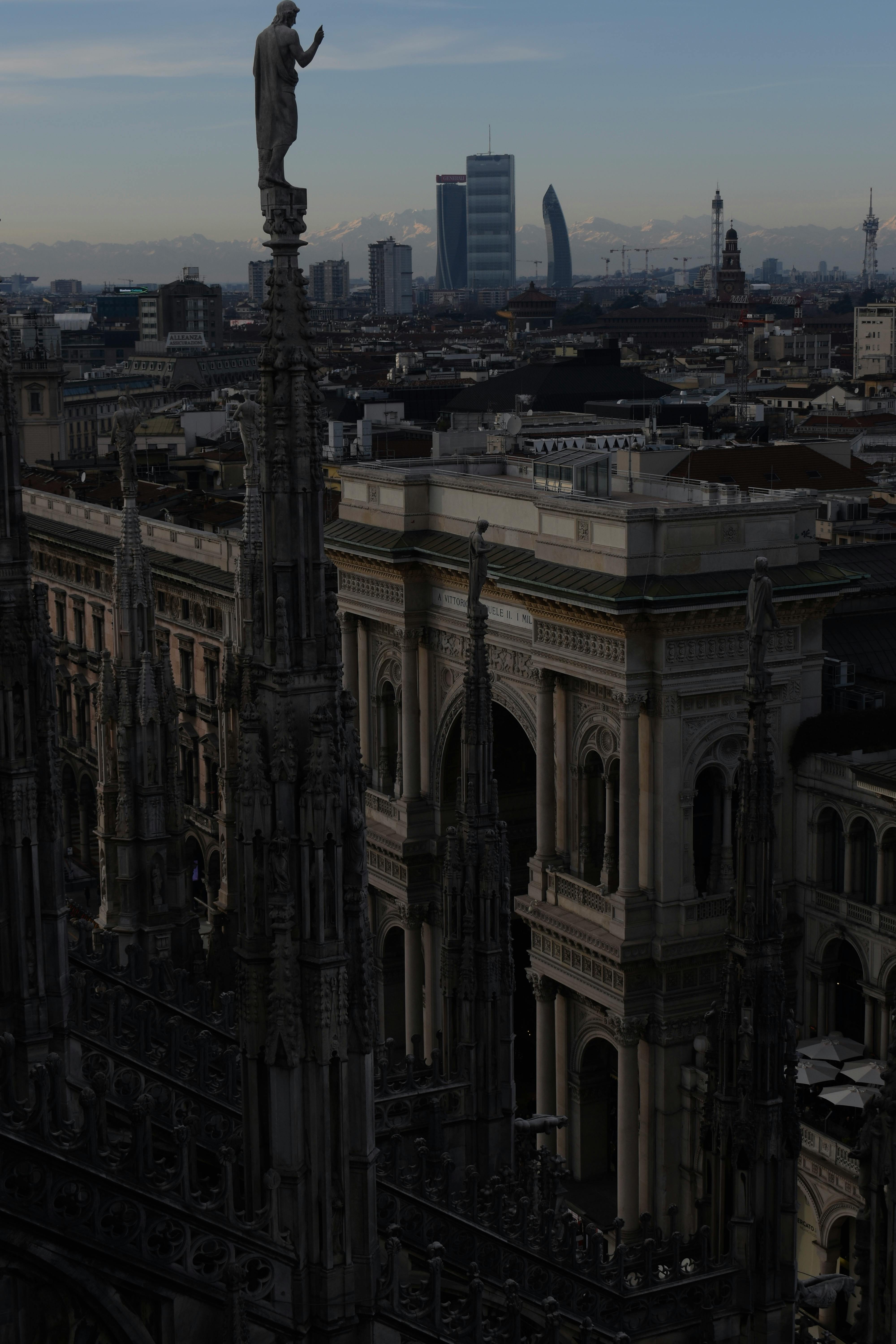 A breathtaking view of Milan Cathedral's spires overlooking the city at dusk, showcasing Gothic architecture.