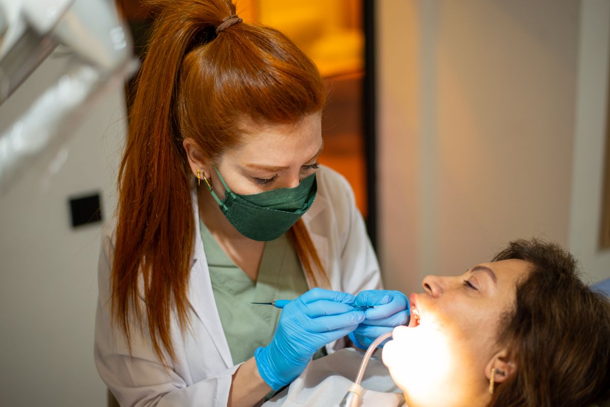 Female dentist examining a woman's teeth during a routine dental checkup