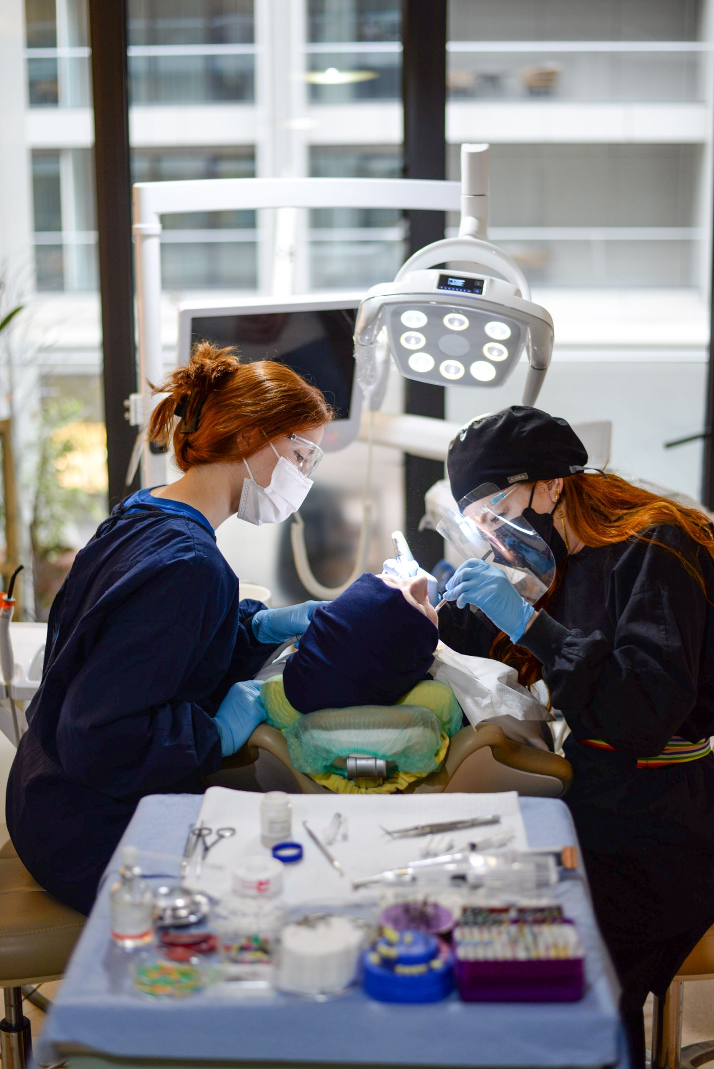 Dentistas atendendo paciente em clínica odontológica moderna