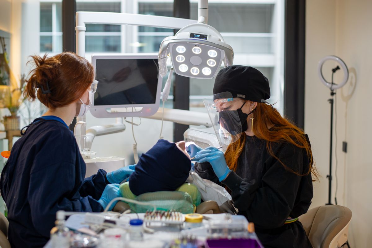 Dentist and assistant treating a patient with modern equipment at Vitalis Dental Studio