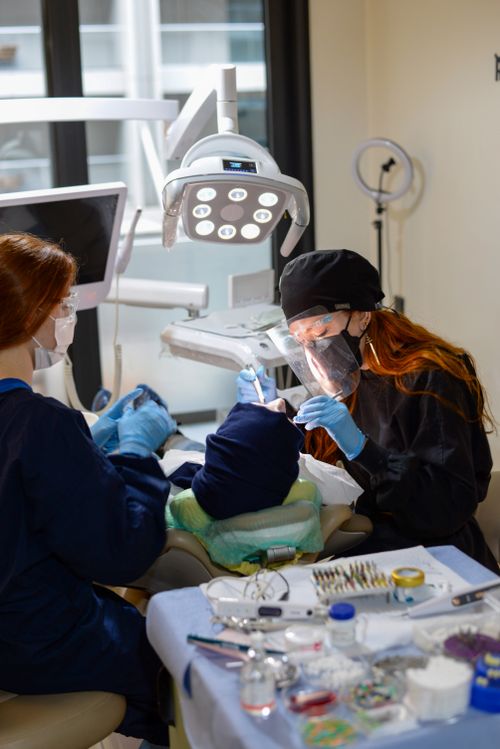 Free Dentists performing a dental checkup with surgical equipment in a modern clinic. Stock Photo