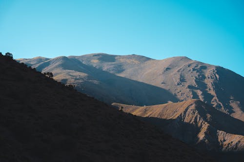 A mountain range with a blue sky in the background