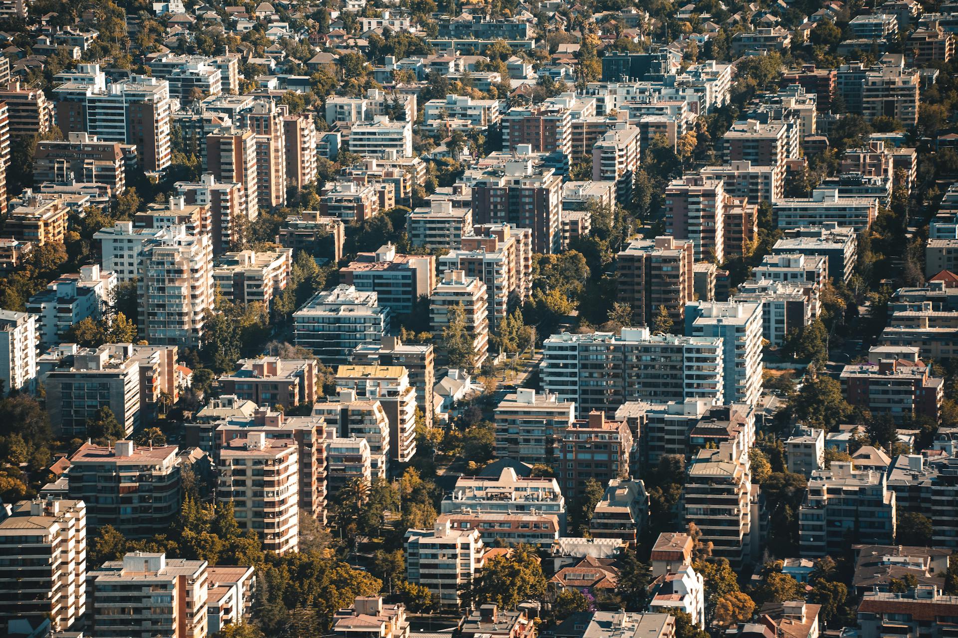 Stunning aerial view of a densely packed urban residential area with tall buildings and greenery.