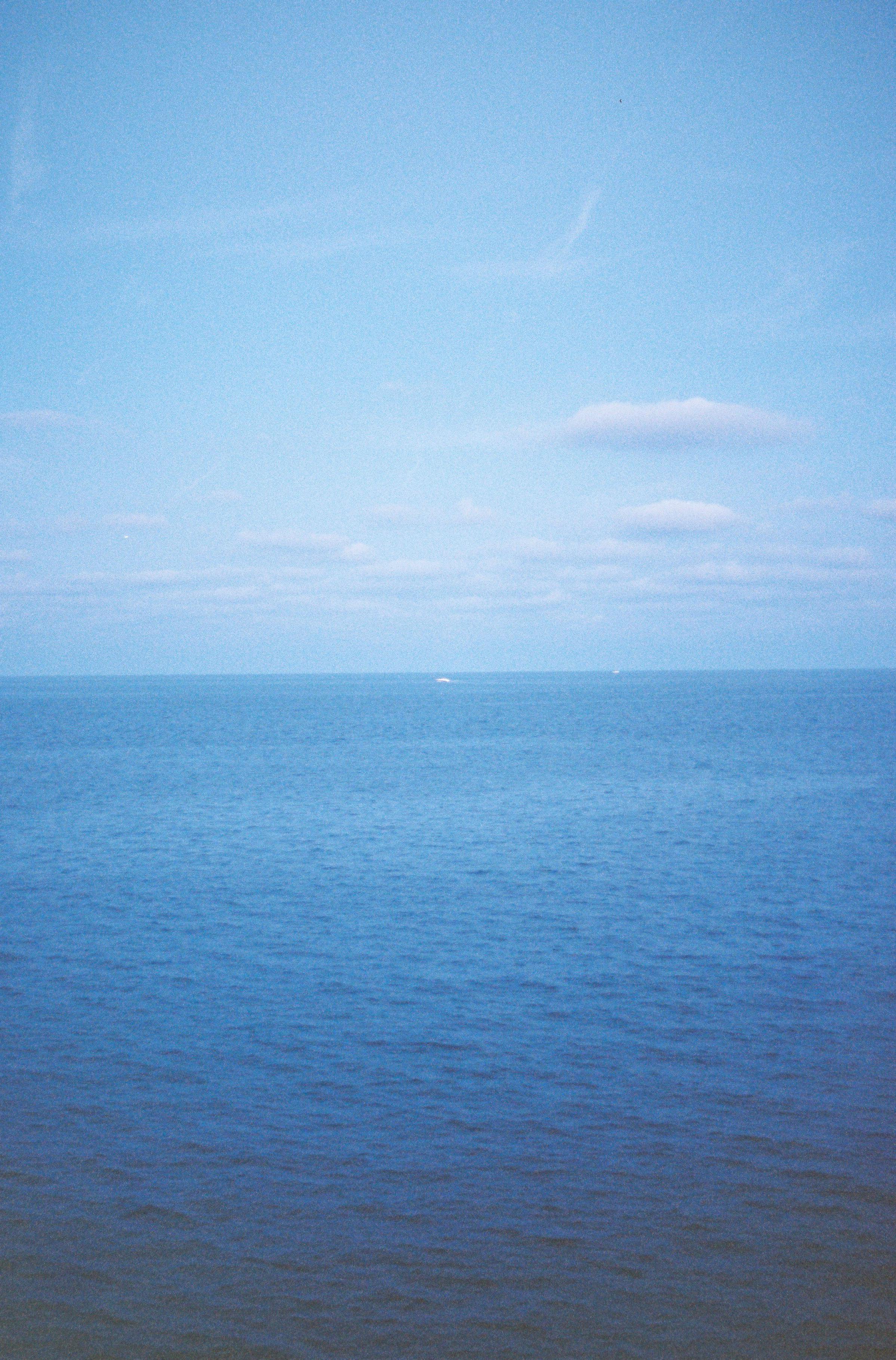 Serene ocean view under a blue sky, capturing nature's calming essence.