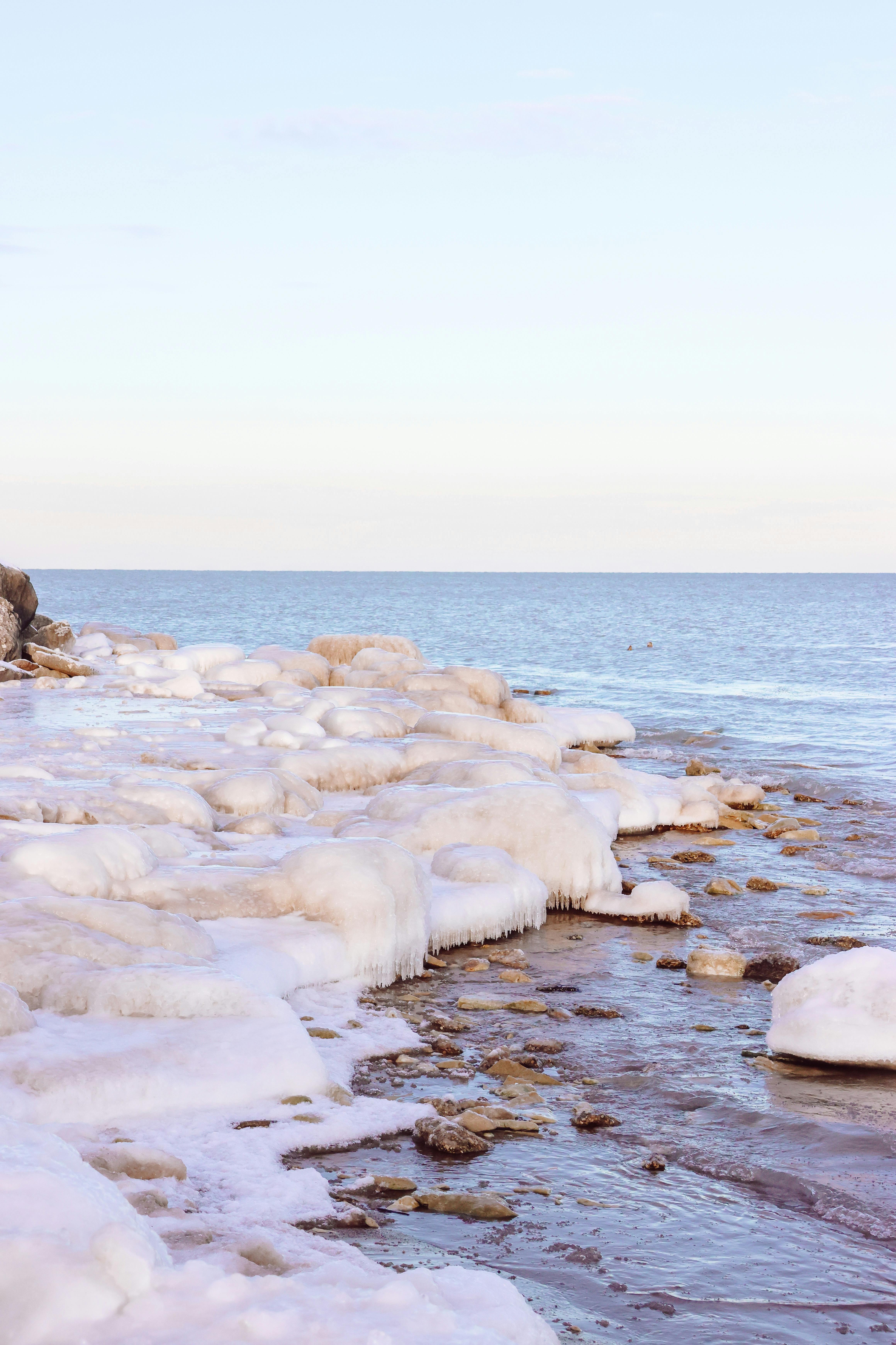 Beautiful ice formations along the shore in Evanston, IL during winter with a clear blue sky.