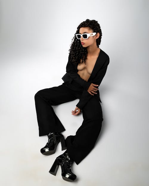 Woman Sitting in Sunglasses and Black Clothes