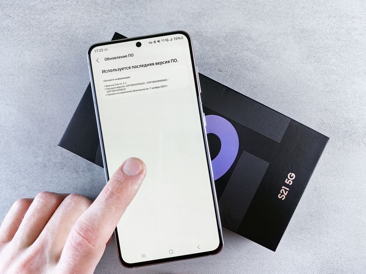 Finger tapping a software update screen on a smartphone