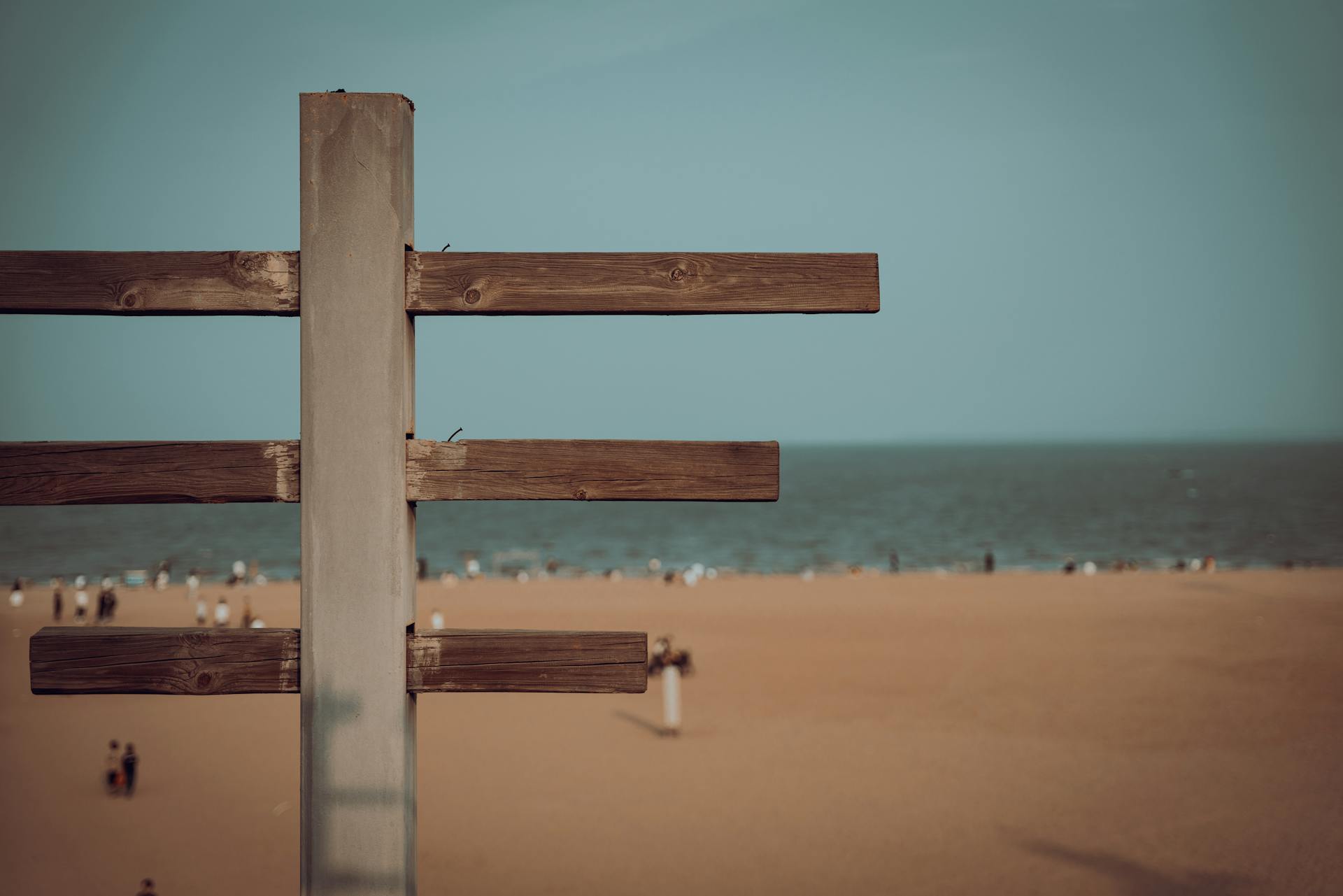 A wooden structure on Xiamen beach with people enjoying a sunny day by the sea in Fujian, China.