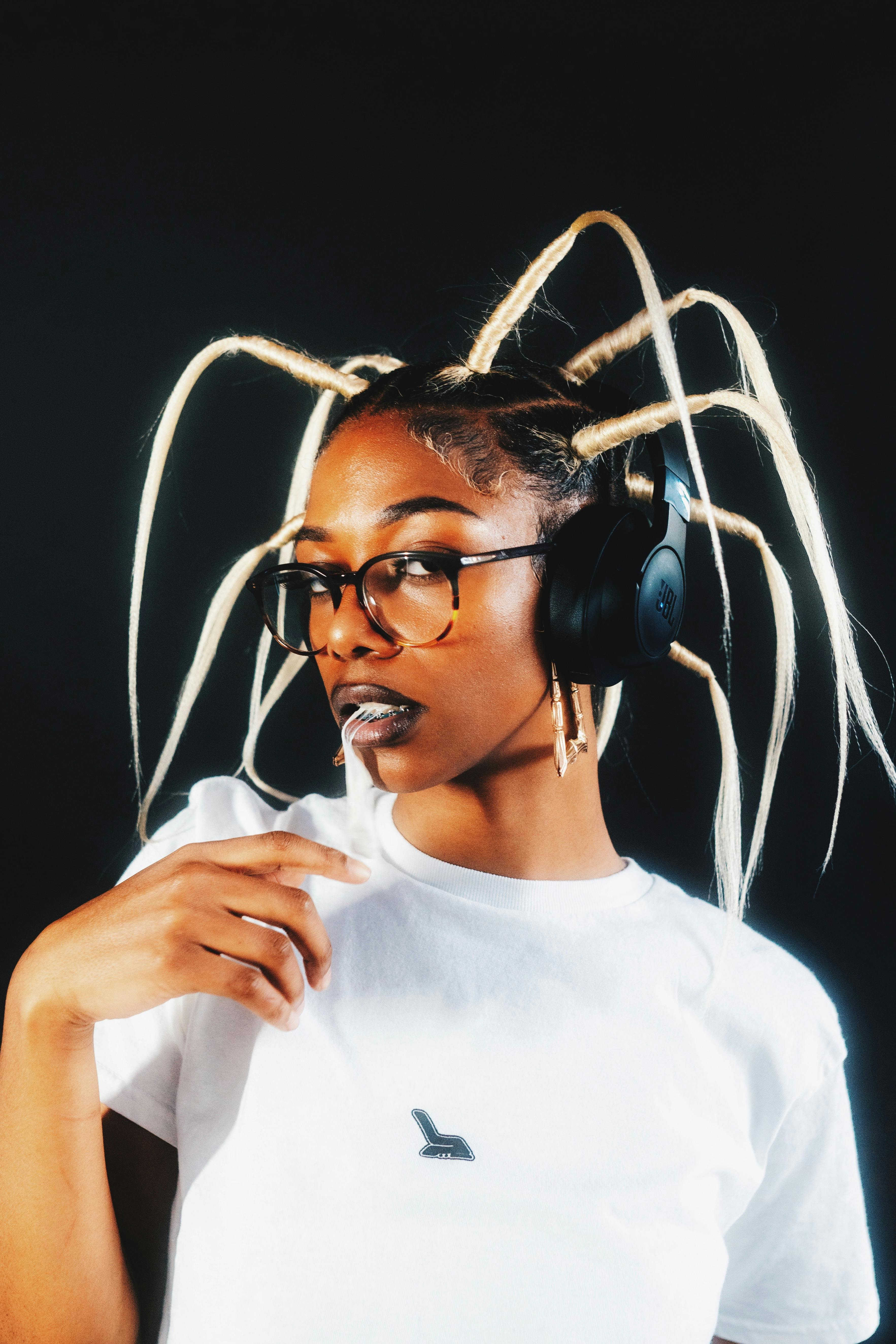 Young black woman with striking hairstyle and headphones in stylish portrait.