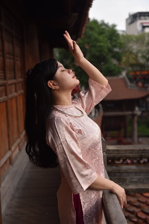 Woman in Traditional Clothing Standing with Arm Raised