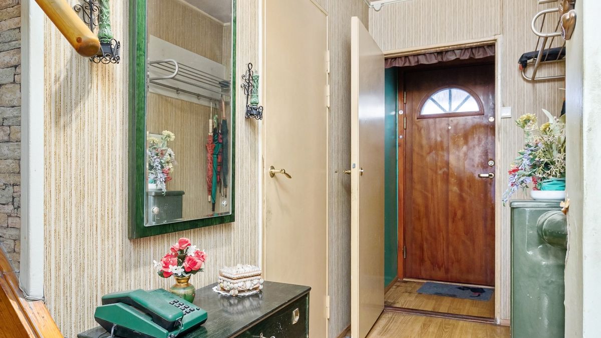 Entree d'appartement ancien avec porte en bois et parquet
