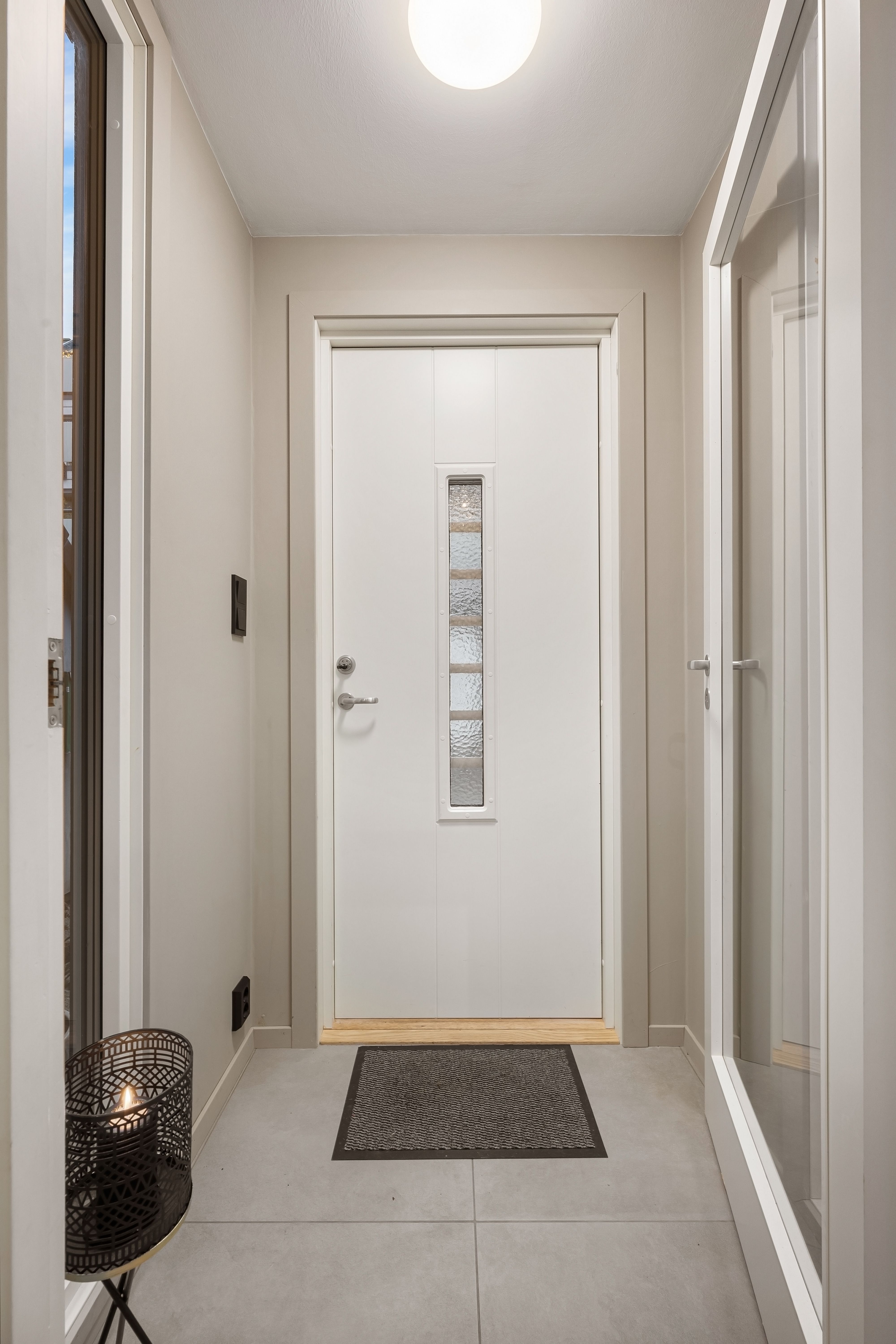 Clean and bright corridor featuring a white door with glass insert, perfect for modern interiors.