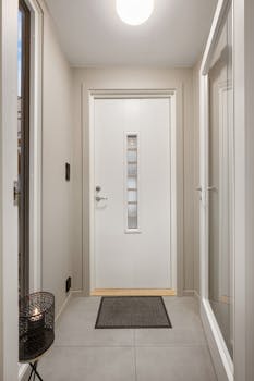 Clean and bright corridor featuring a white door with glass insert, perfect for modern interiors.