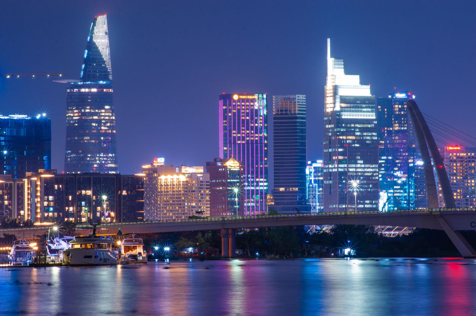 Ho Chi Minh City's skyline lit at night and reflected in the river
