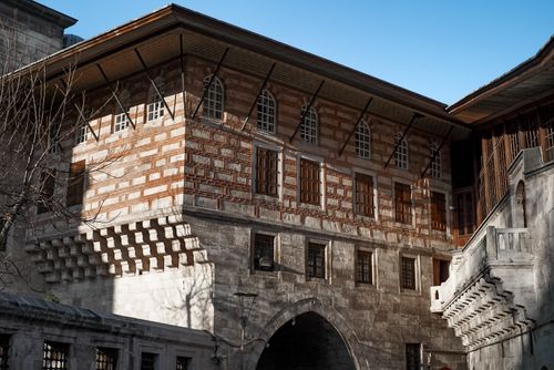 Free Low angle shot of a historical stone building with arched windows and intricate brickwork. Stock Photo