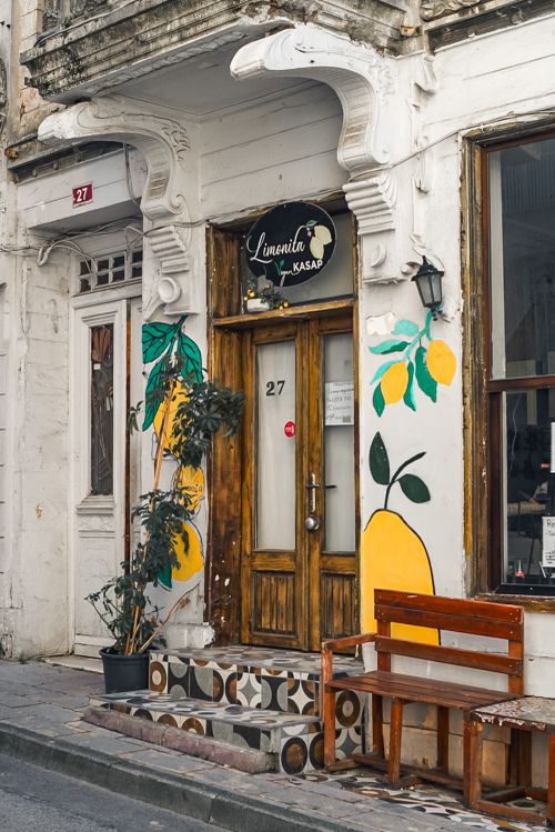 Free Rustic café entrance adorned with lemon art and rustic bench. Inviting atmosphere for visitors. Stock Photo