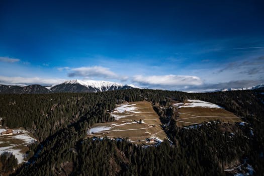 A stunning aerial view of snow-covered mountains and forests in winter.