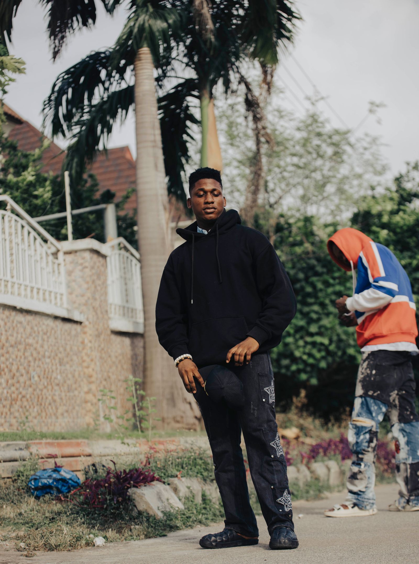 Hombre con hoodie negro en estética urbana de verano
