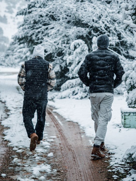Back View of Man Walking on Dirt Road in Snow · Free Stock Photo