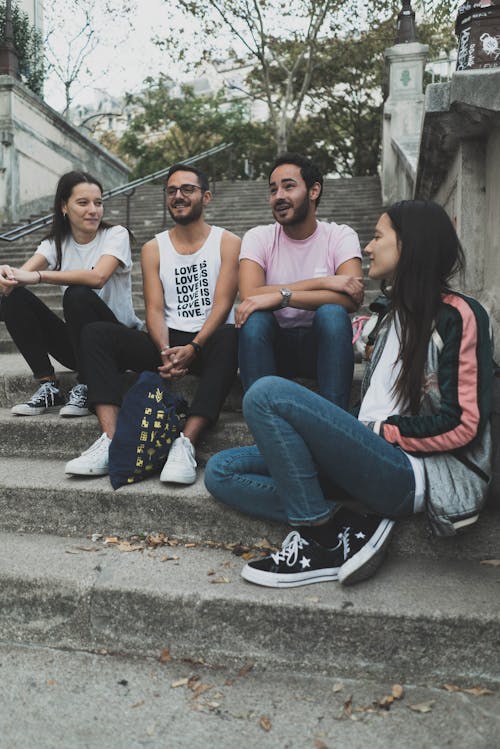 Free Group of Friends Sitting on Concrete Stairs Stock Photo