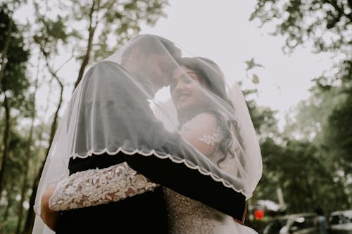 Newlyweds Hugging under Veil