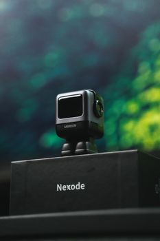 A sleek Nexode charger showcased on a box against a blurred background, highlighting modern technology.