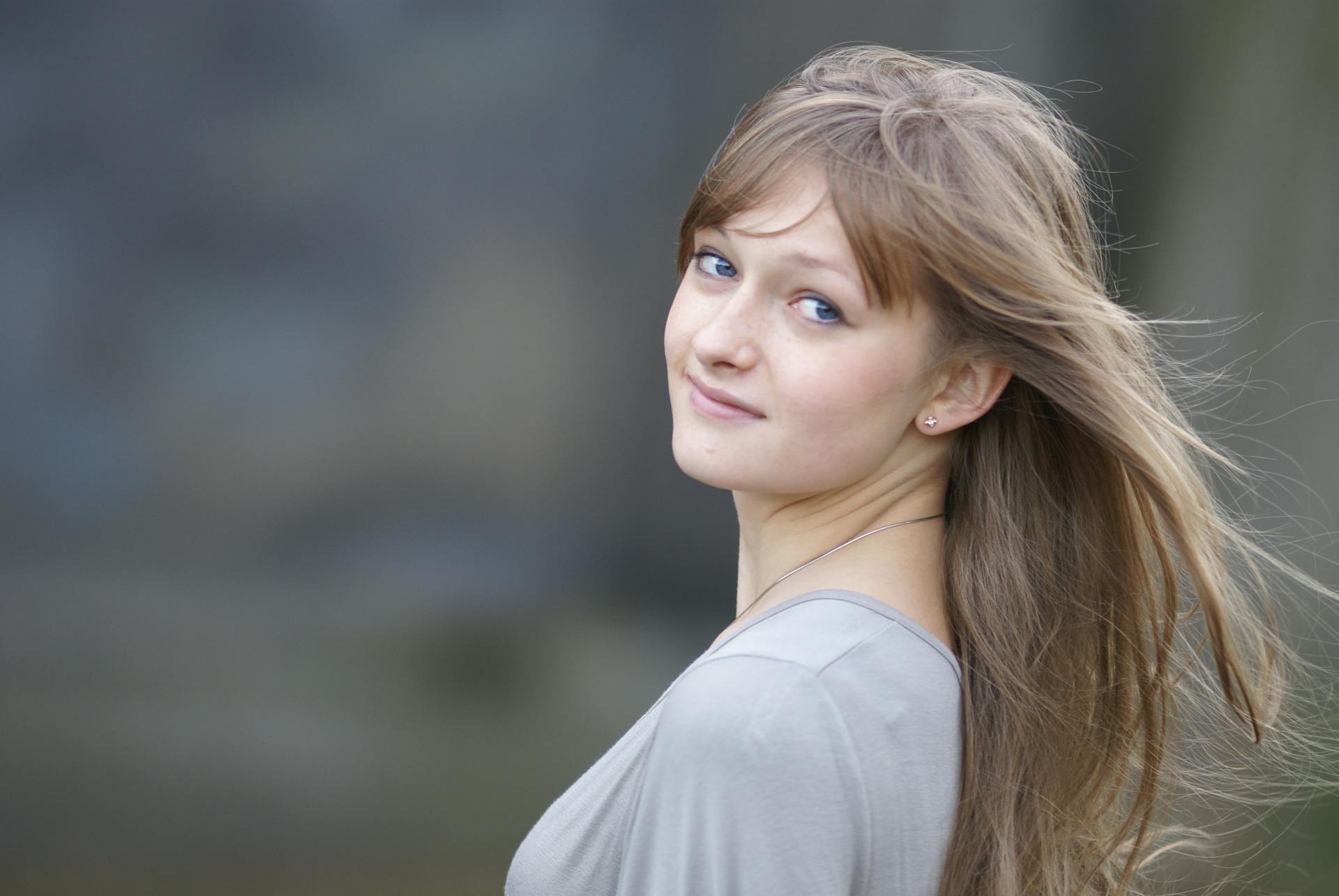 Une jeune femme aux cheveux longs pose pour un portrait.