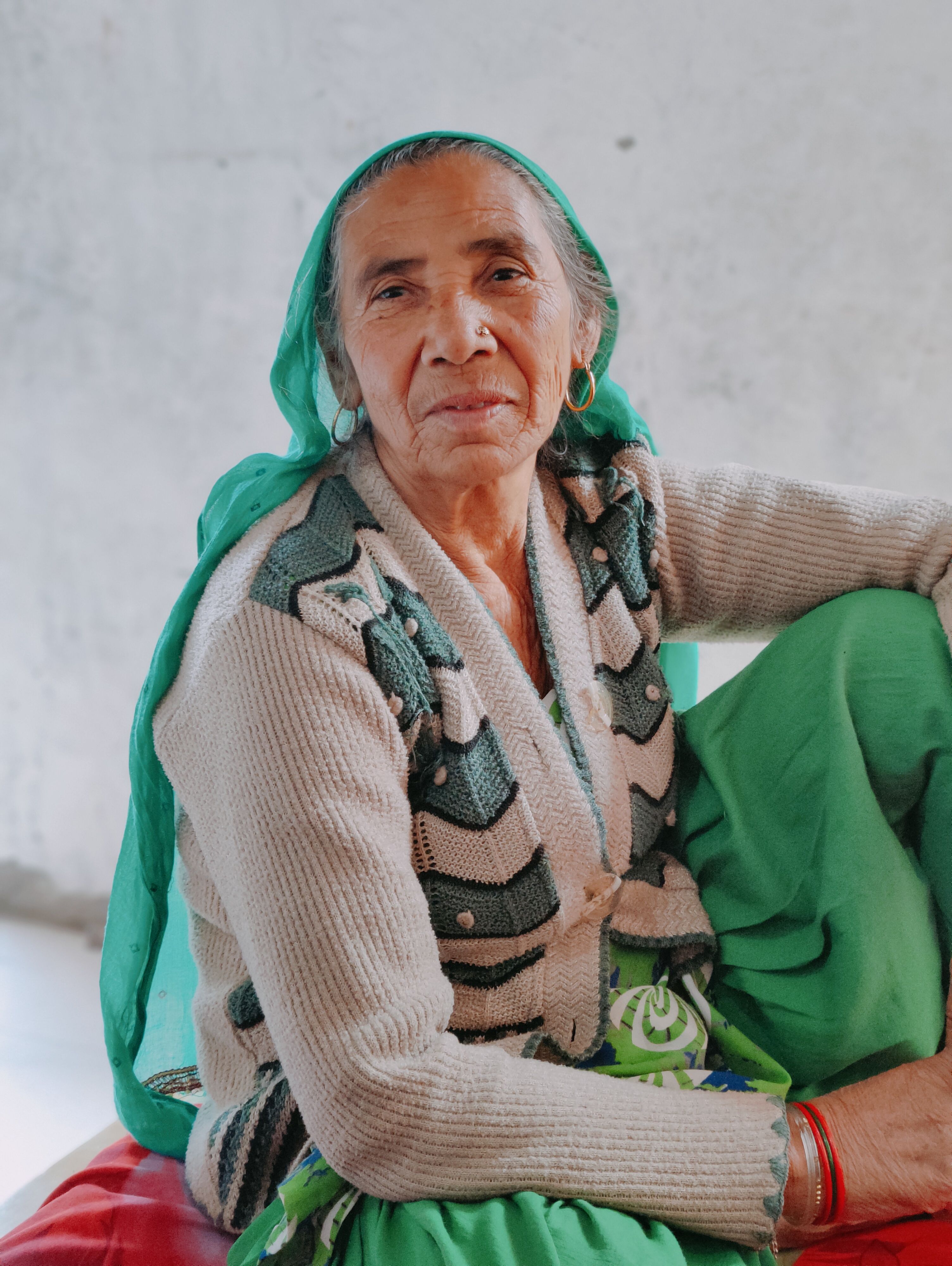 Portrait of an elderly woman in Ghaziabad, India, wearing a headscarf and cardigan.
