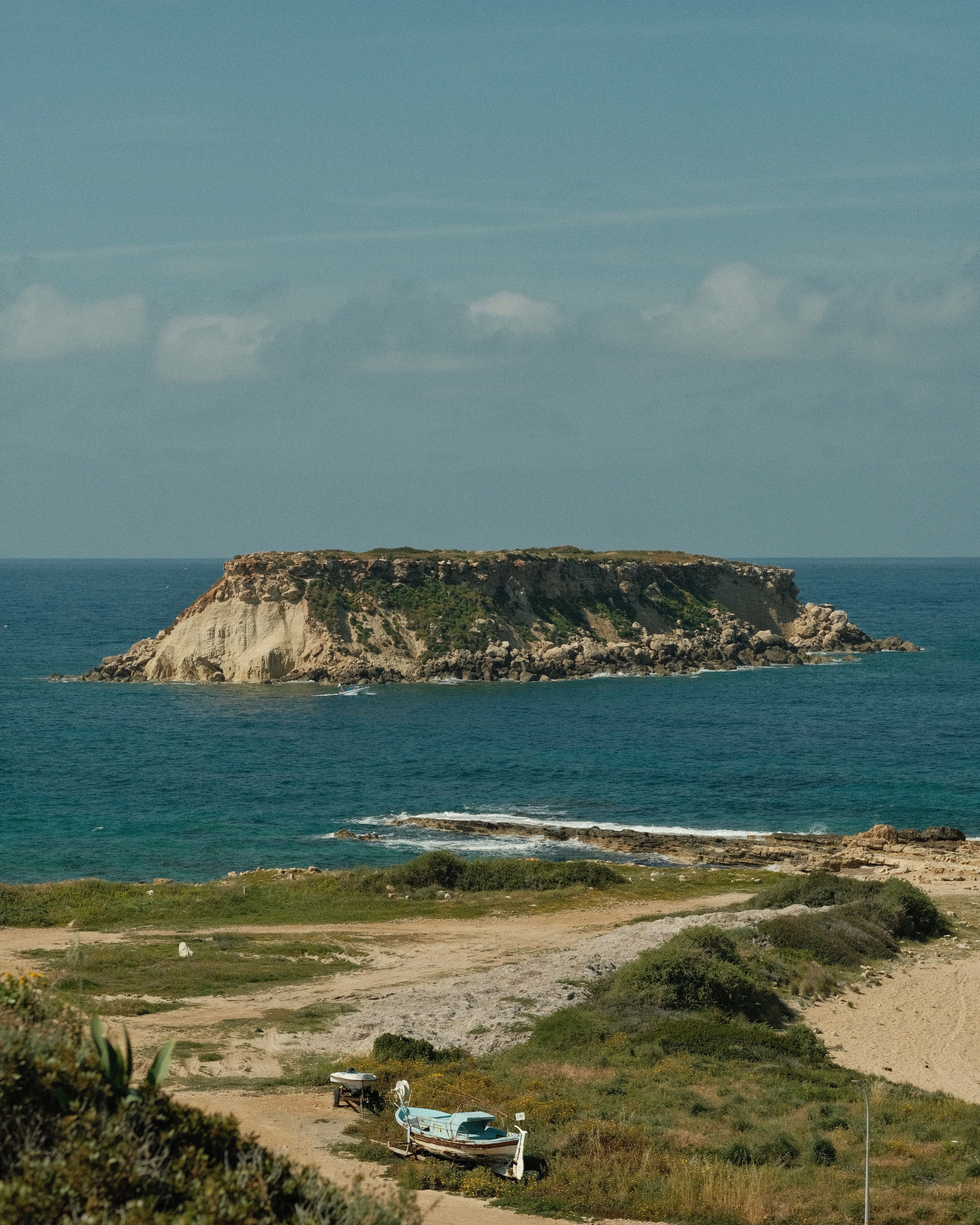 A picturesque island off the coast with rocky cliffs and a serene ocean view.