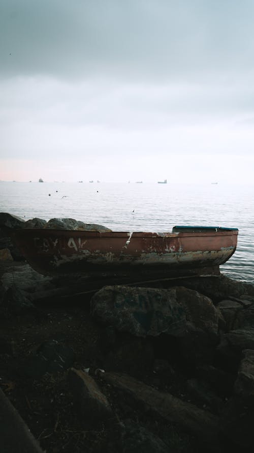 Foto profissional grátis de barco, lago, pedras