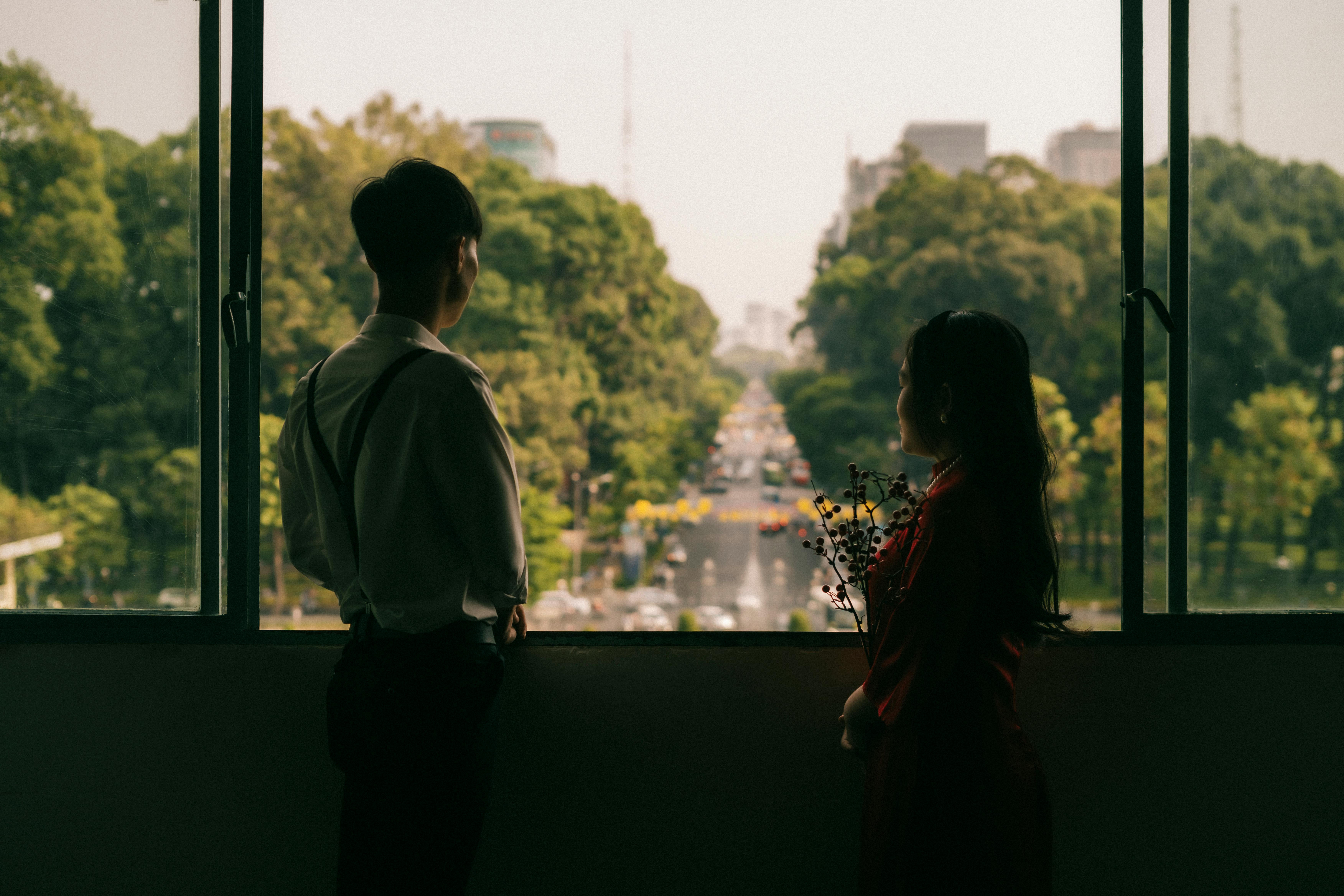 A couple looks out over a leafy avenue in Ho Chi Minh City, Vietnam.