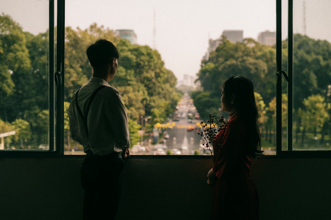 Young Couple Standing and Looking out the Window 