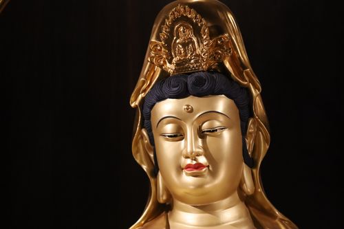 Free A close-up of a golden Buddha head statue against a black background, symbolizing peace and spirituality. Stock Photo