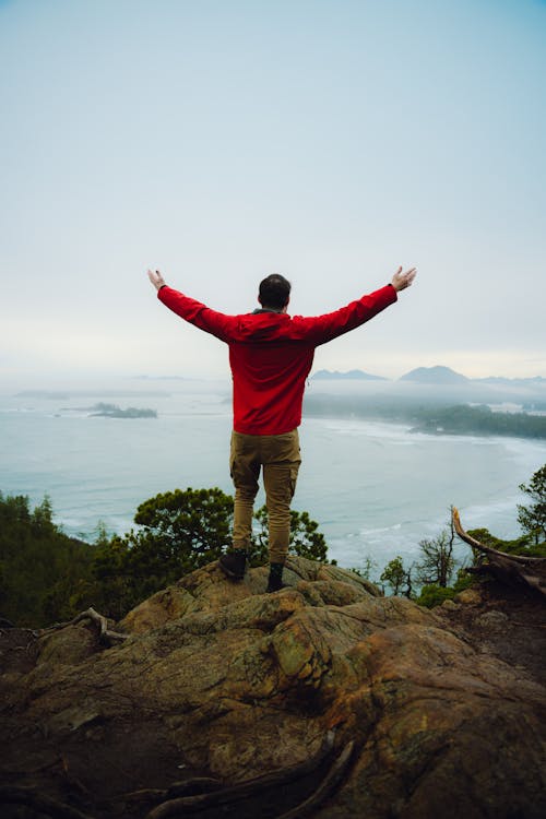 Happy Hiker in Red Jacket Standing on Cliff