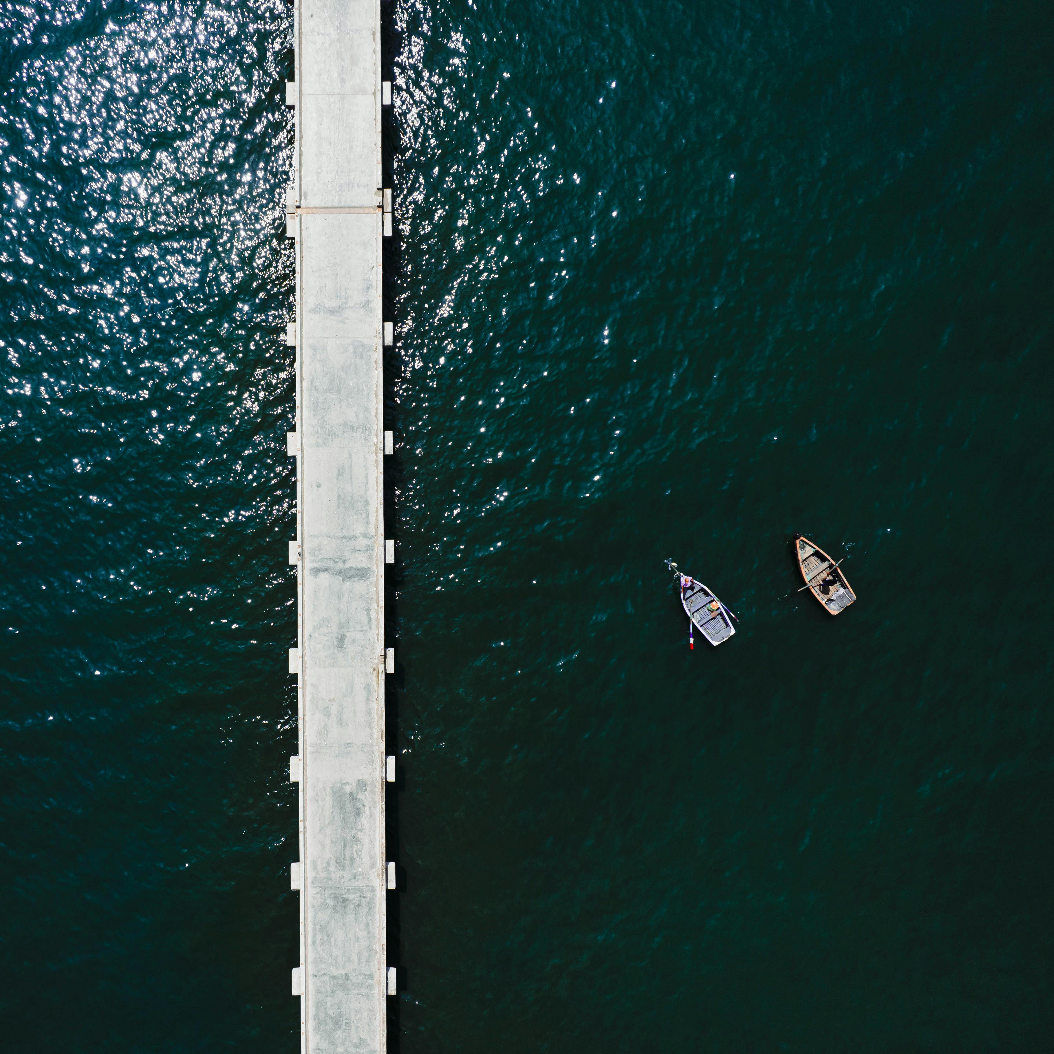 Top view of two boats near a pier in Huacho, Peru, highlighting coastal serenity.