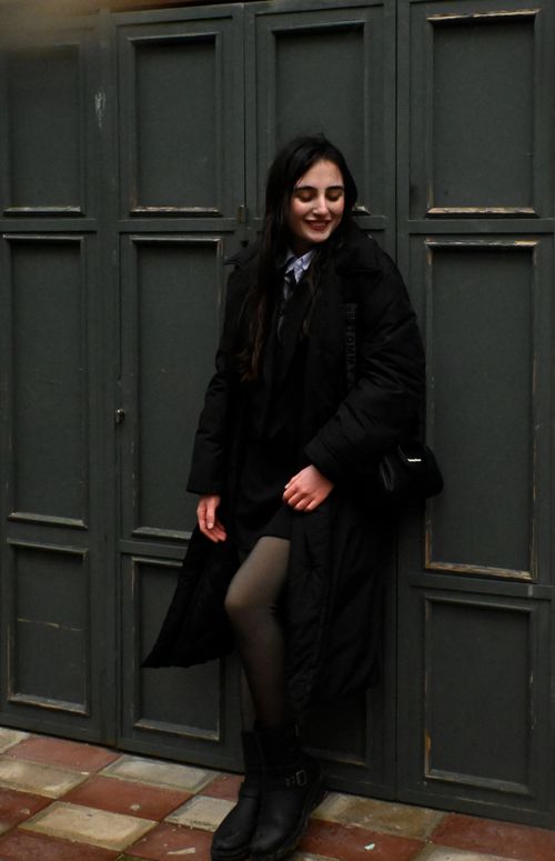 Free Fashionable woman in dark outfit smiling against urban backdrop Stock Photo