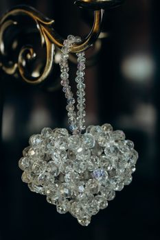 Elegant heart-shaped crystal bead pendant hanging on ornate metal holder.