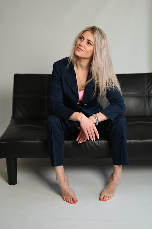 Blonde Woman in Suit Sitting on Sofa