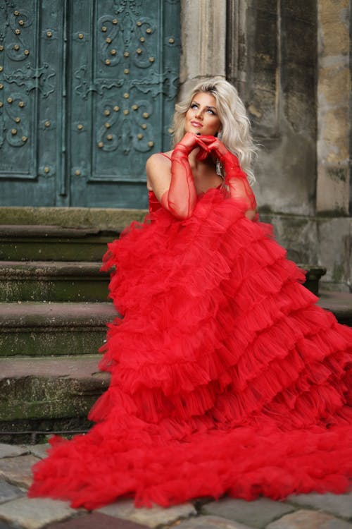 Blonde Woman in Red Dress Sitting on Stairs