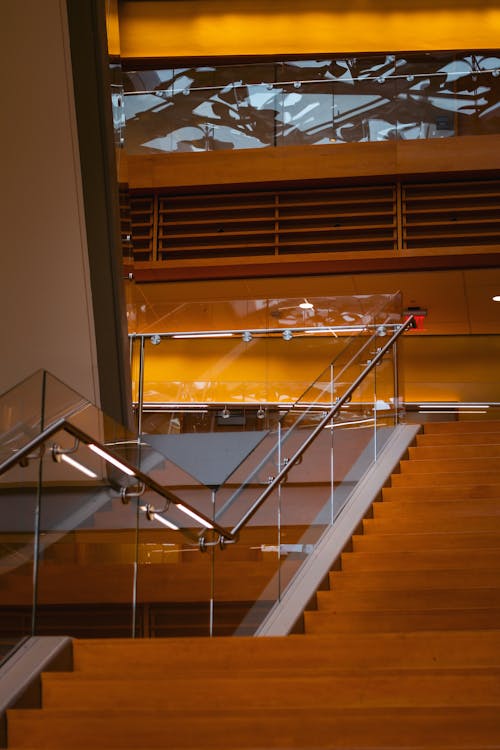 A glass staircase with a glass railing and a glass wall