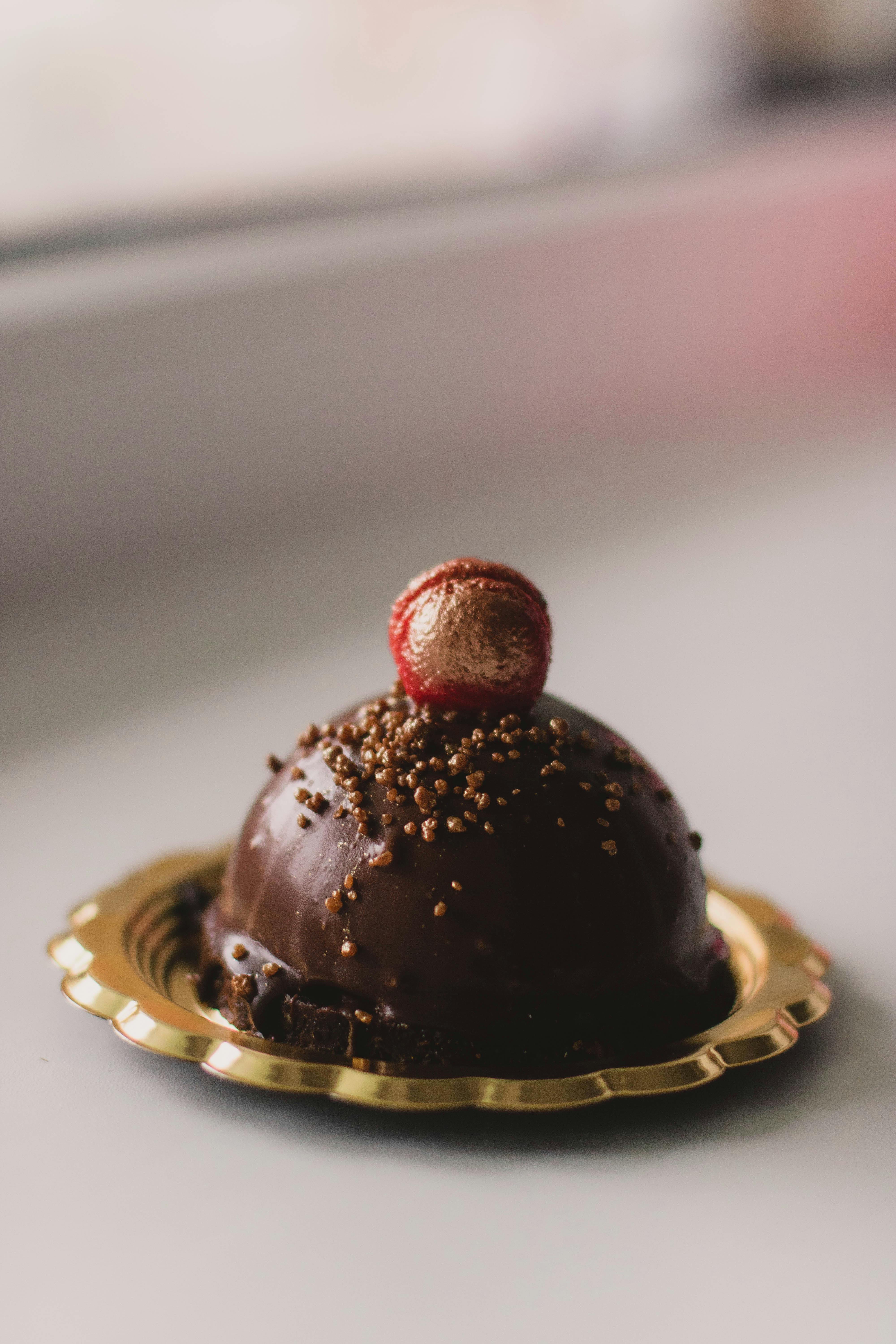 close up photo of chocolate cake on a gold colored saucer