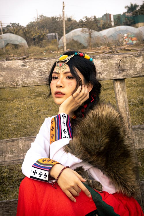 Woman Sitting in Traditional Clothing 
