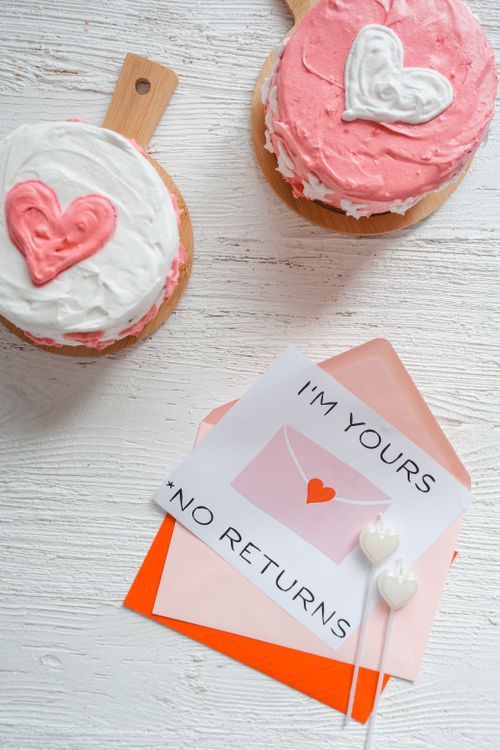 Free Heart-shaped cakes and a love note on white background, perfect for romantic occasions. Stock Photo