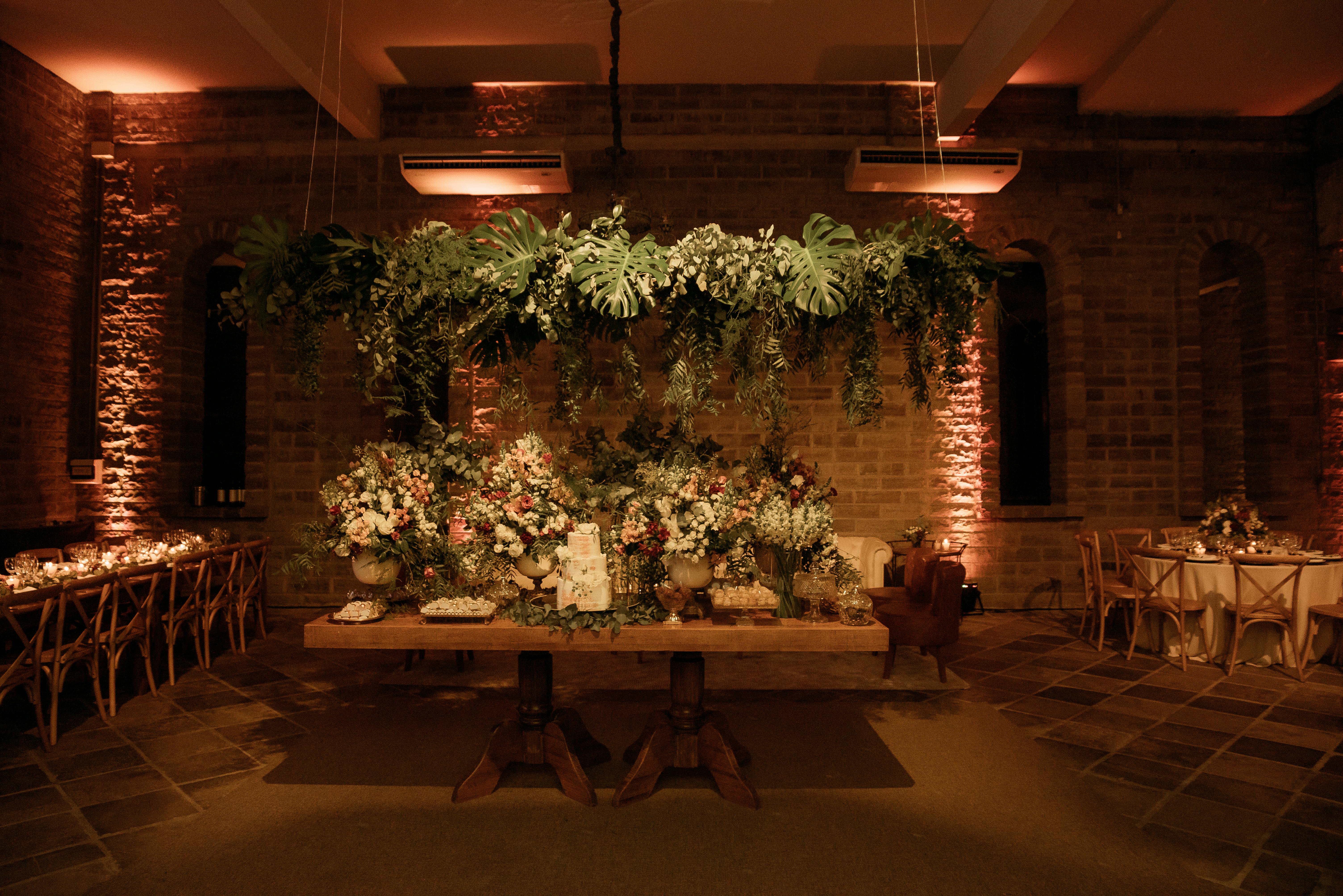 A beautifully decorated indoor venue with lush floral arrangements and mood lighting.