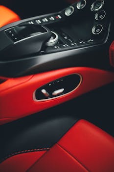Close-up of a luxury car interior featuring red leather and modern controls.