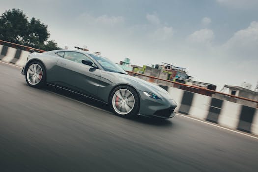 A stylish grey sports car speeding on an urban highway in Delhi, India.