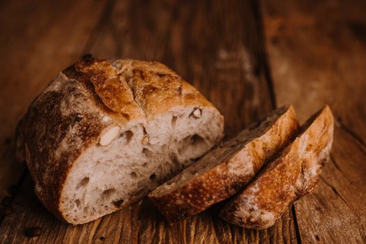 Close-up of sliced rustic artisan bread on a wooden table, showcasing texture and freshness.