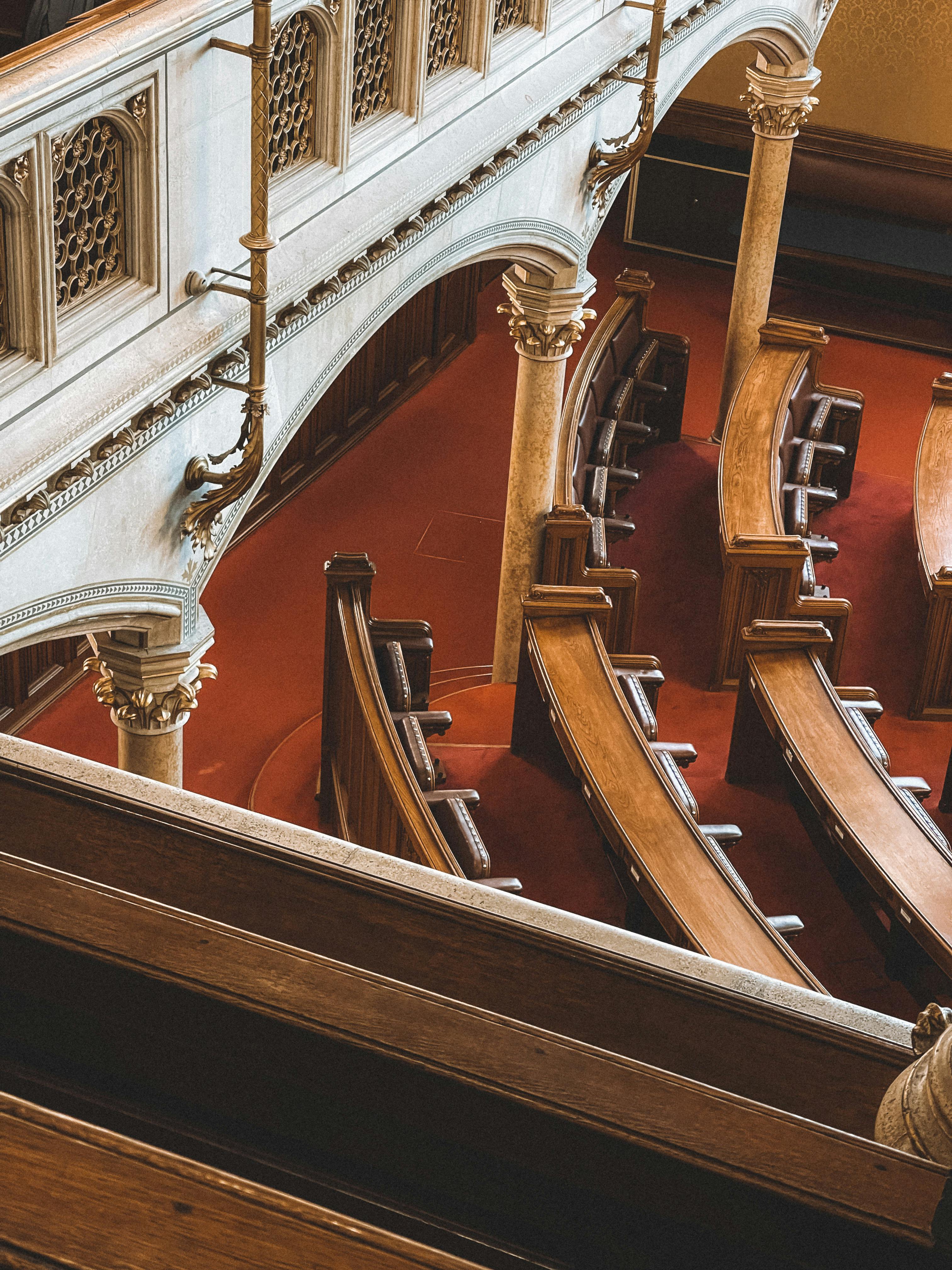 Historic Viennese hall interior with ornate design and curved wooden seating, captured from above.